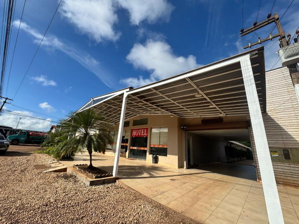 a building with a garage with a palm tree in front at Big Hotel in Imperatriz