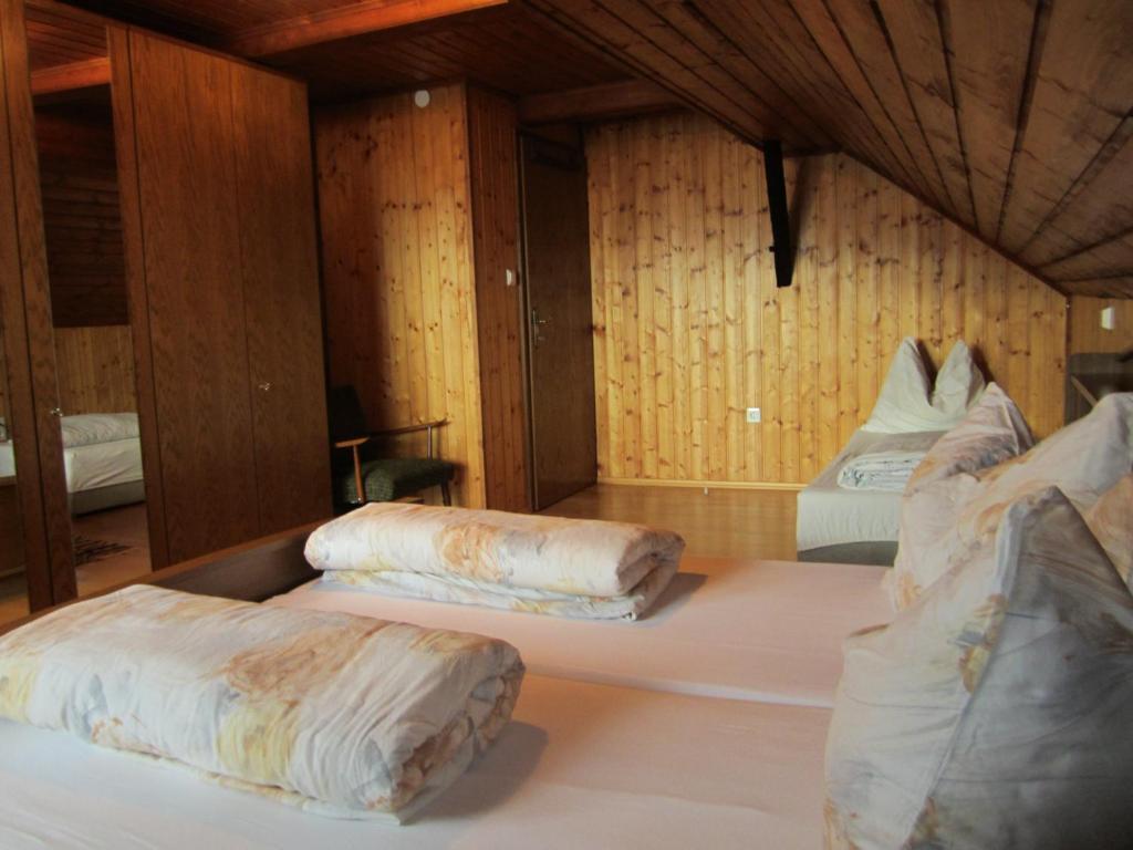 two beds in a room with wooden walls at Ferienwohnungen am Pietschacherhof in Hochrindl