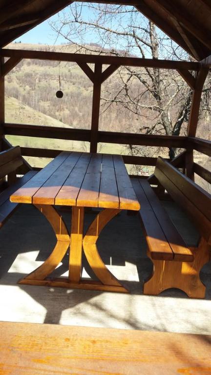 a wooden picnic table sitting under a gazebo at Cabana Bunicilor in Răchiţele