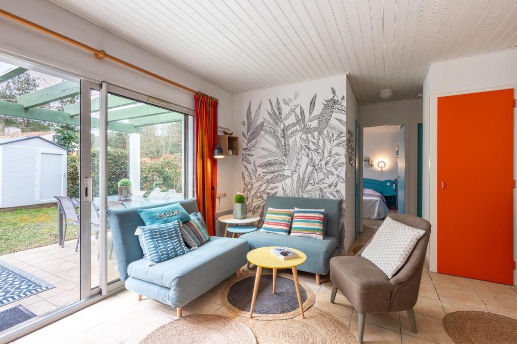 un salon avec un canapé bleu et des chaises dans l'établissement Le Victoria - Proche de la Plage, à Saint-Jean-de-Monts