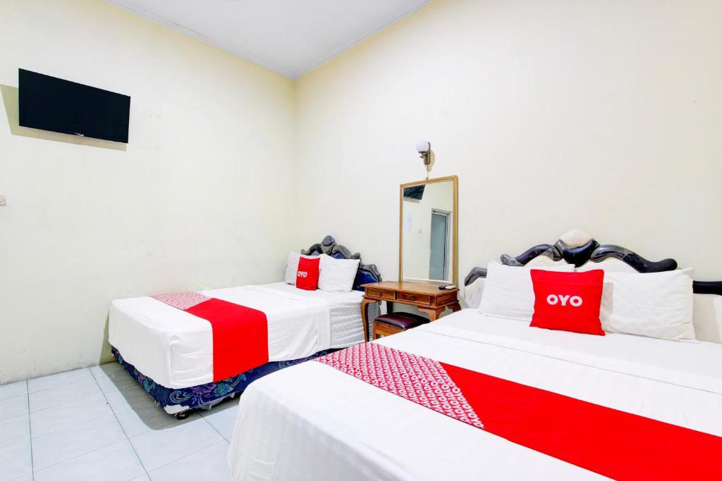 Postel nebo postele na pokoji v ubytování Hotel O Jalan Malioboro Near Stasiun Tugu Yogyakarta Formerly Hotel Baru