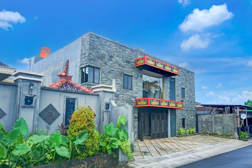 a stone house with a red roof at Hotel O Kedaton Near Rumah Sakit Advent Bandar Lampung Formerly Hotel Plain C Lake in Bandar Lampung