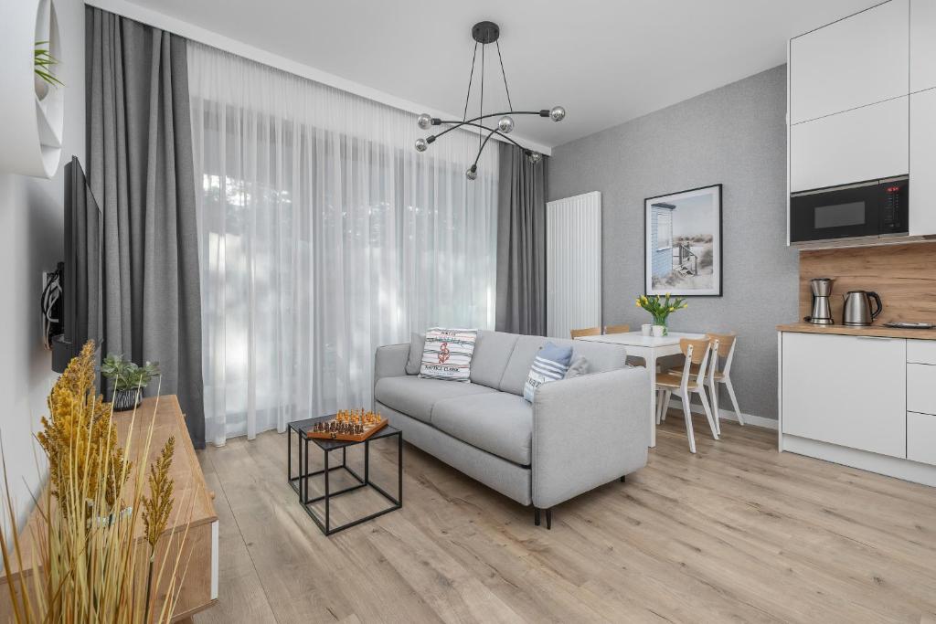 a living room with a couch and a table at Apartament Relax Rogowo Balkon & Parking by Noclegi Renters in Rogowo