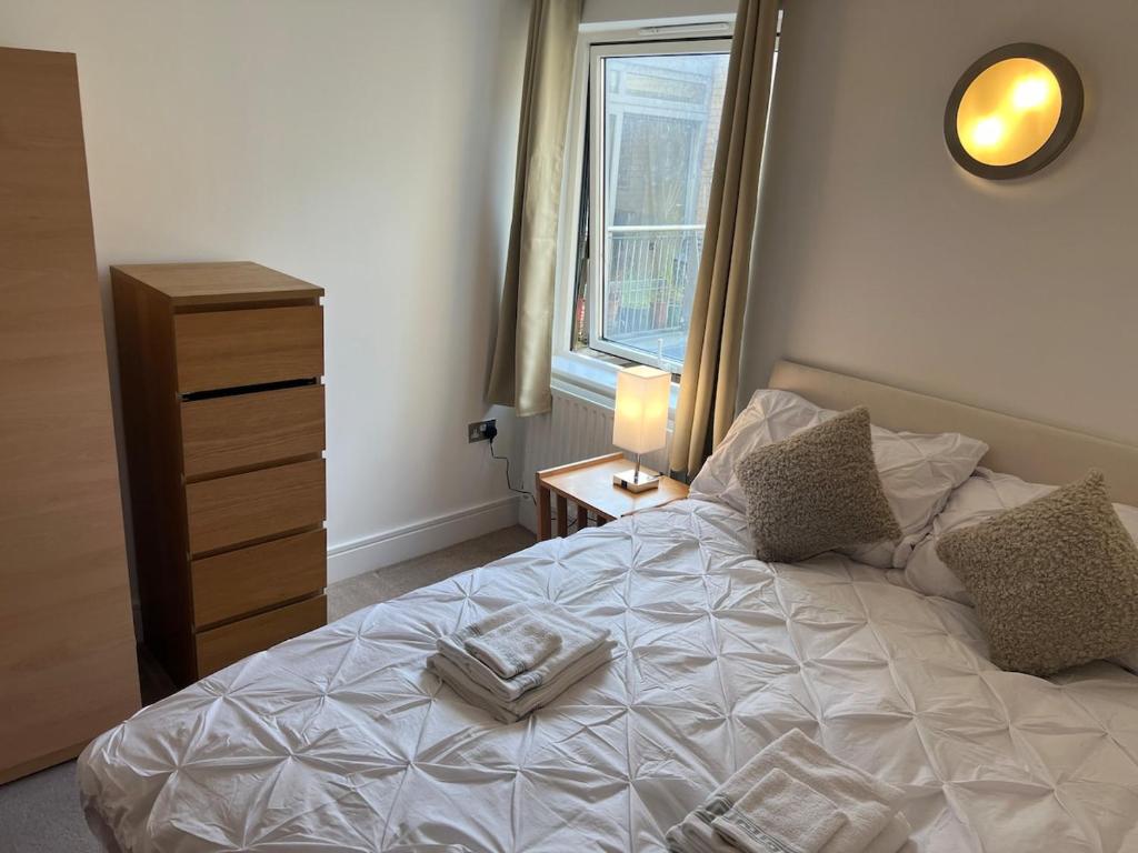 a bedroom with a bed with a dresser and a window at jjkjs in London