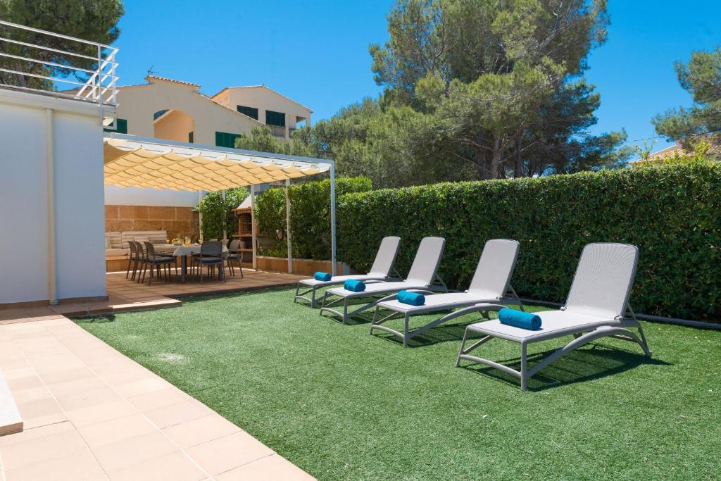 eine Gruppe von Gartenstühlen auf dem Rasen in der Unterkunft Can Roig -Caldes- in Colònia de Sant Pere