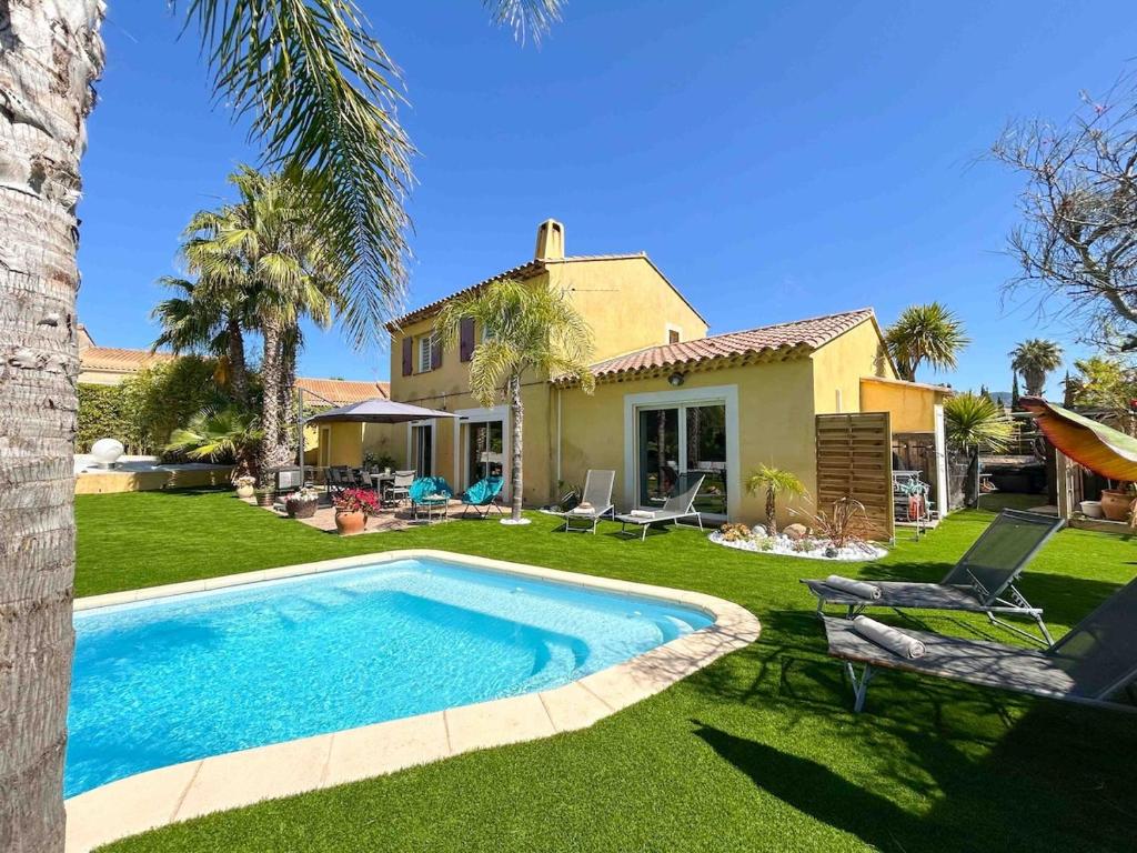 une cour avec une piscine et une maison dans l'établissement Maison spacieuse avec piscine à Sanary-sur-Mer, à Sanary-sur-Mer