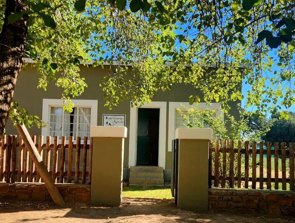 a house with a fence and a sign in front of it at Karoorus Mossie -Loxton Overnight Stay in Loxton