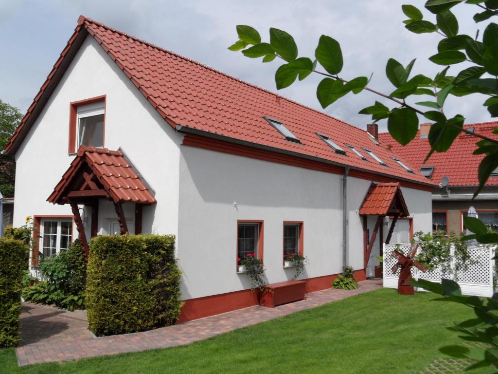Casa blanca con techo rojo en Ferienwohnung Blick zu den Sternen, en Hohenbrück