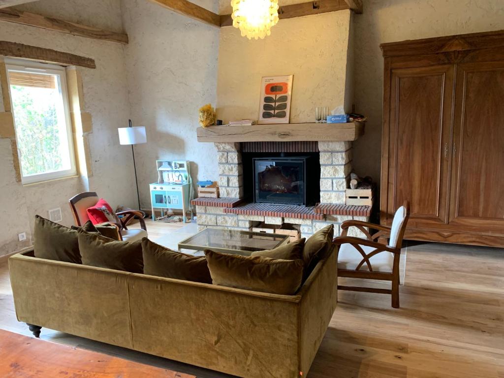 a living room with a couch and a fireplace at Maison de campagne-proche Parc Le Pal in Diou