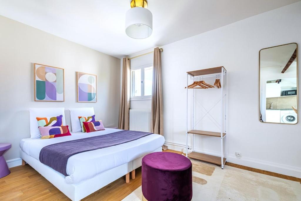 - une chambre avec un grand lit et un tabouret pourpre dans l'établissement Studio coloré proche Paris Parc des Princes- III, à Issy-les-Moulineaux