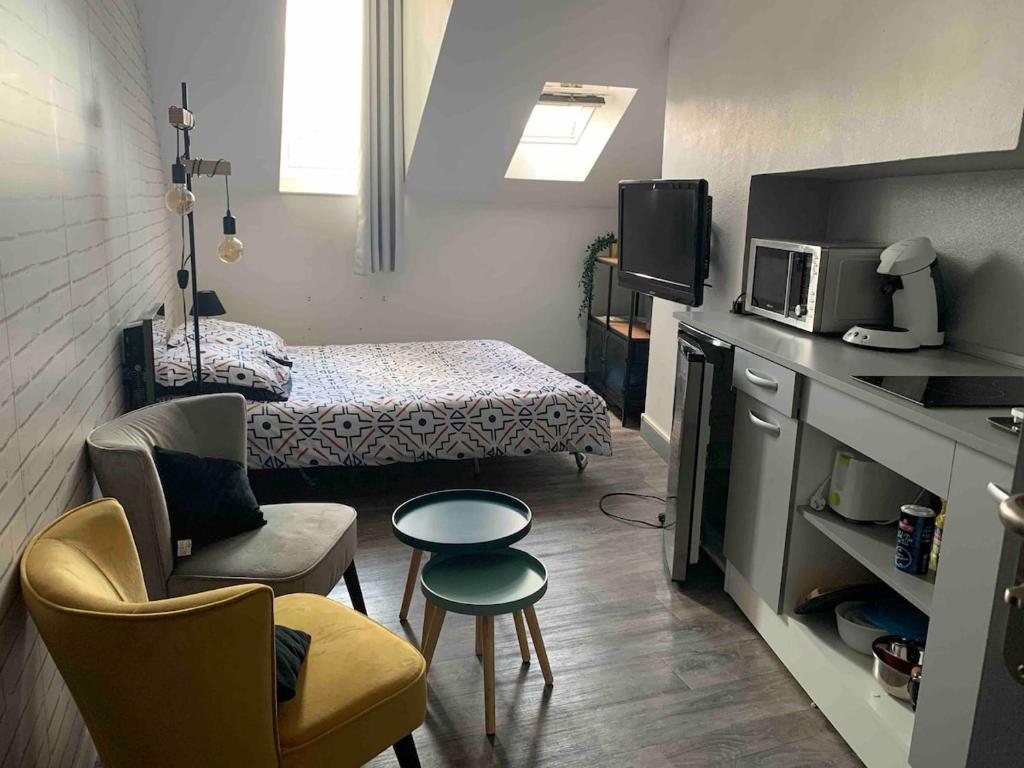 a small room with a bed and a microwave at Studio proche gare centre ville au calme côté cour in Orléans