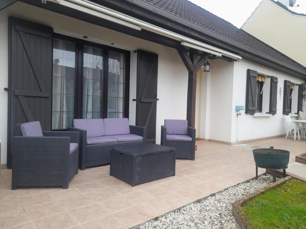 d'une terrasse avec 2 chaises et des coussins violets. dans l'établissement Charmante maison sur Auxerre, à Auxerre