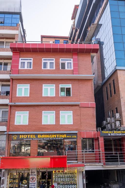 a red brick building with a store in a city at OYO 825 Hotel Baikuntha in Kathmandu