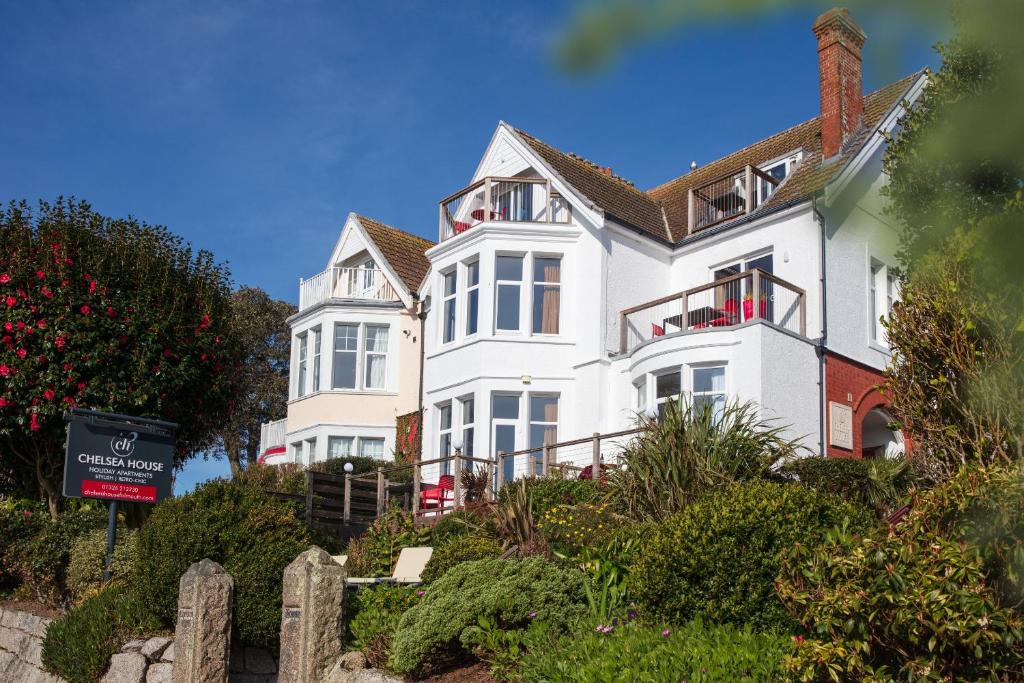 a large white house on top of a hill at Chelsea House Holiday Apartments in Falmouth