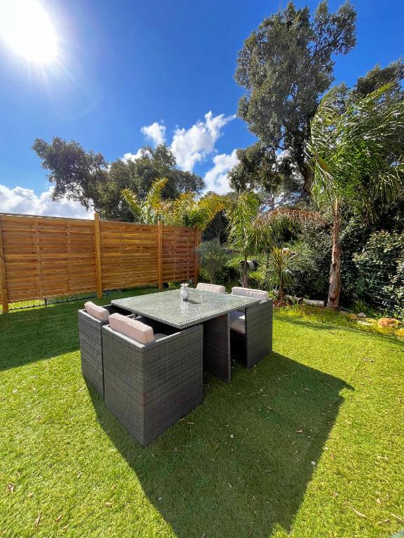 d'un jardin avec une table et des chaises dans la pelouse. dans l'établissement Chez Eugene, à La Londe-les-Maures