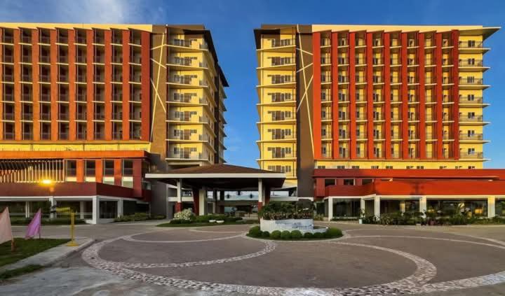 zwei hohe Gebäude in einer Stadt mit einem Parkplatz in der Unterkunft Primeworld District Casa De Hanna in Lapu Lapu City