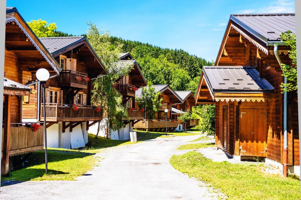 Une rangée de maisons en bois dans une rue dans l'établissement Résidence Néméa Les Chalets du Bois de Champelle, à Morillon