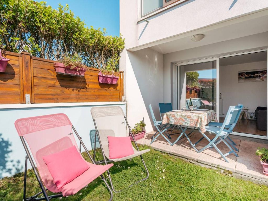 un groupe de chaises et une table dans une cour dans l'établissement Carnac : Appartement T2 de standing, 49m², proche marché, plage et Thalasso, Parking Inclus - FR-1-477-243, à Carnac