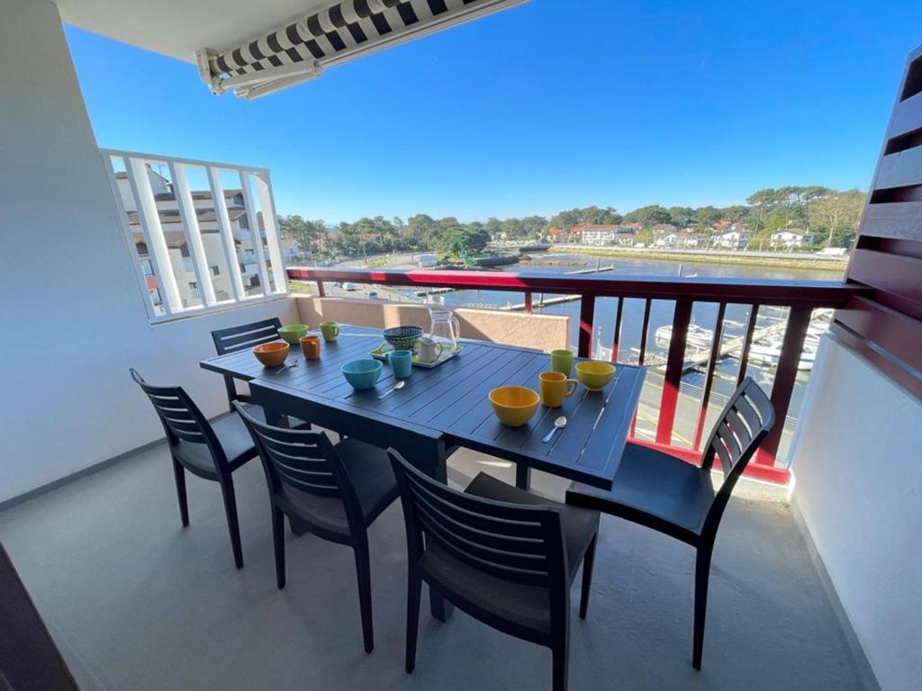 une table bleue et des chaises sur un balcon dans l'établissement Appartement cosy 4 pers avec piscine et parking à Capbreton - FR-1-413-256, à Capbreton