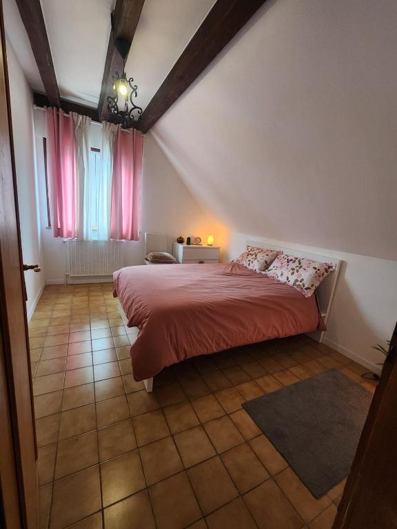 - une chambre dotée d'un lit avec des draps rouges et des rideaux roses dans l'établissement MIN HISELE, Ma PETITE MAISON, à Lingolsheim