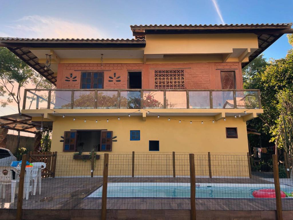 a house with a balcony and a swimming pool at Casa de Praia Itacimirim Bahia - Piscina e Conforto in Camacari