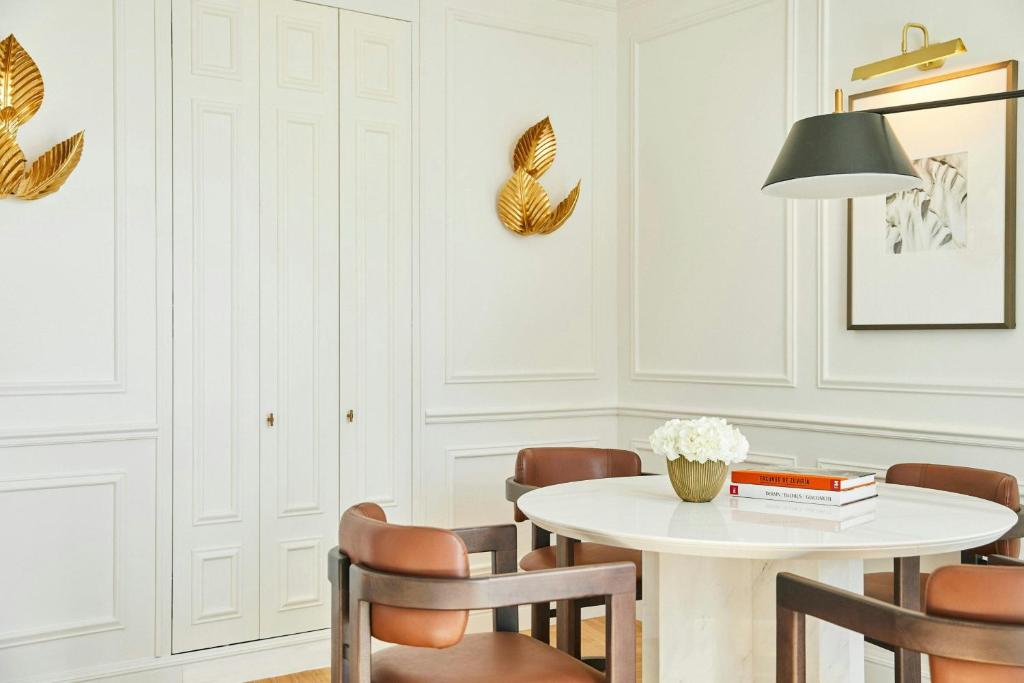 a white dining room with a table and chairs at The Palace, a Luxury Collection Hotel, Madrid in Madrid