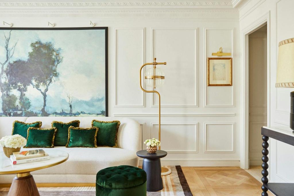 a living room with a white couch with green pillows at The Palace, a Luxury Collection Hotel, Madrid in Madrid