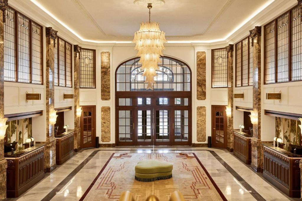 a large lobby with a chandelier and a large door at The Palace, a Luxury Collection Hotel, Madrid in Madrid