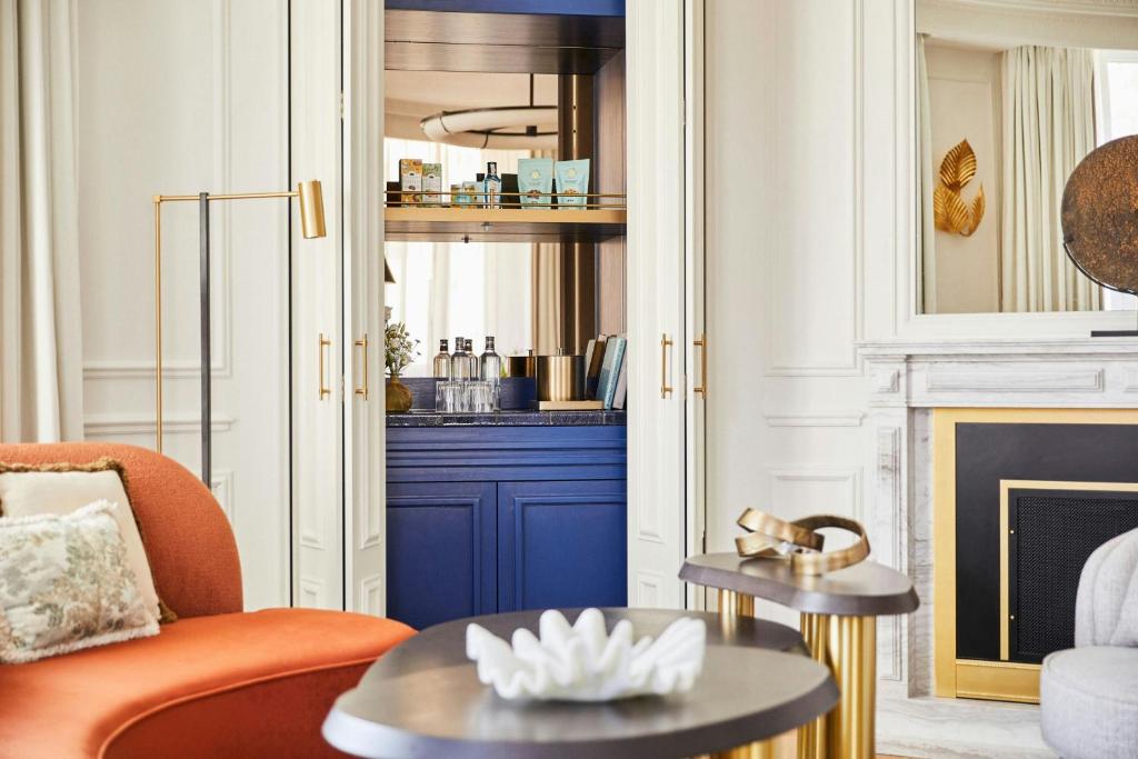 a living room with an orange chair and a fireplace at The Palace, a Luxury Collection Hotel, Madrid in Madrid