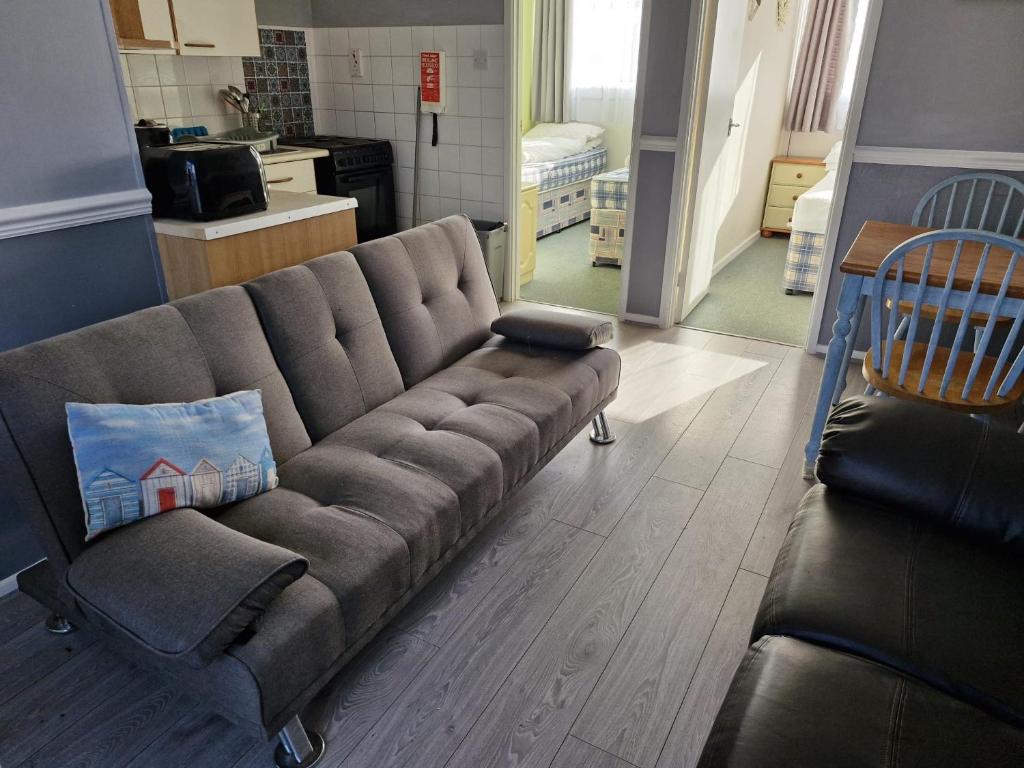a couch in a living room with a laptop on it at Parkview Retreat in Hemsby