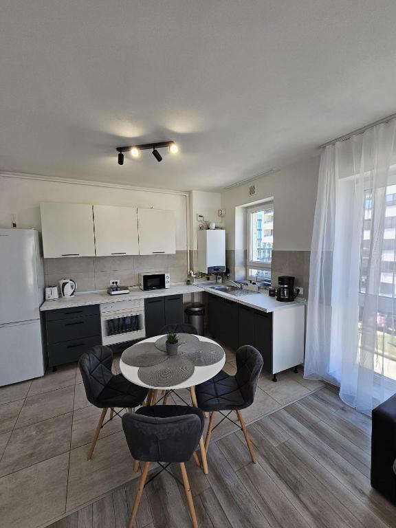 a kitchen with a table and some chairs and a table at Coresi Mall Luxury Apartment in Braşov