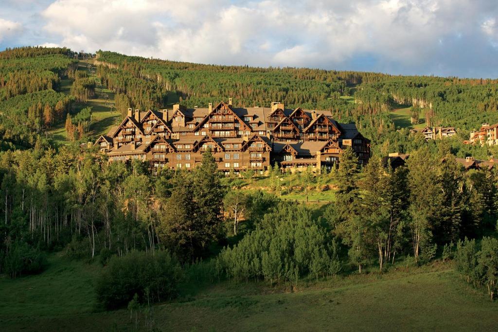 a large building on top of a hill with trees at The Ritz-Carlton, Bachelor Gulch in Beaver Creek