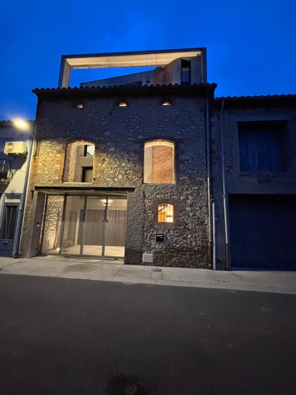 un edificio de ladrillo con una ventana en una calle en La Grange, en Argelès-sur-Mer