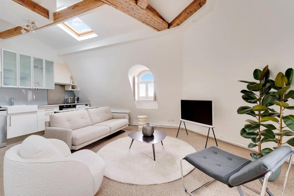 un salon avec un canapé blanc et une table dans l'établissement Loft d'exception Courcelles - parc Monceau, à Paris