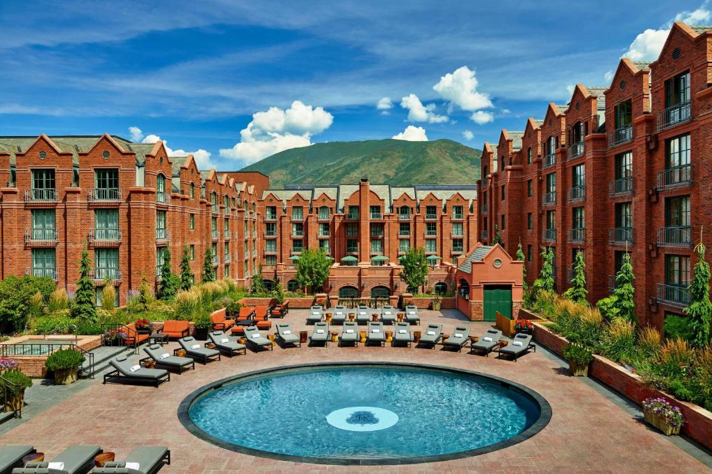 a hotel with a courtyard with chairs and a pool at St. Regis Aspen Resort in Aspen