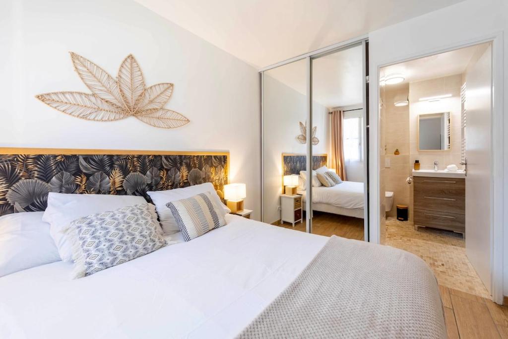 a bedroom with a large white bed and a mirror at Séjour magique à 10 min de Disneyland- Appartement cosy avec terrasse & parking privé in Bailly-Romainvilliers