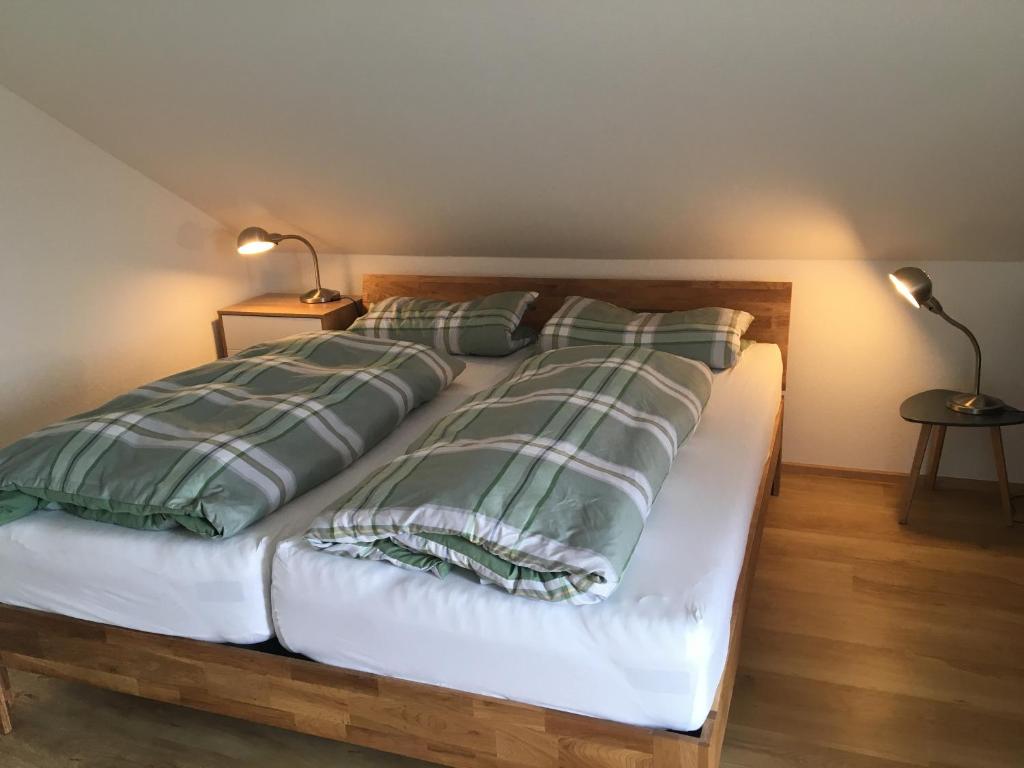 a bed with green and white pillows on it at Ferienwohnung Eulennestle in Lenzkirch