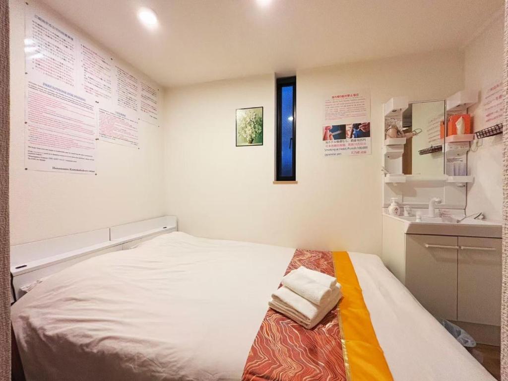 een bed in een kamer met een muur met posters bij Hananogo Ikebukuro - Vacation STAY 09224v in Tokyo