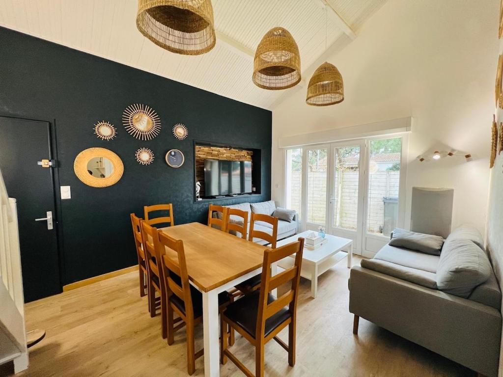 une cuisine et une salle à manger avec une table et des chaises dans l'établissement A l'ombre des pins, à La Terrière