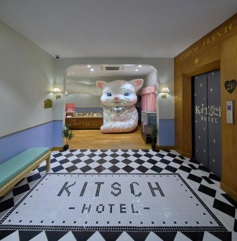 a room with a painting of a cat on the wall at Kitsch Hotel in Bangkok