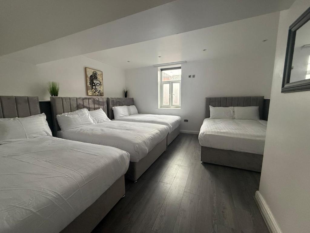リバプールにあるAmazing 10 bed apt on Mathew Street Sleeps 18のベッド3台とソファが備わる部屋