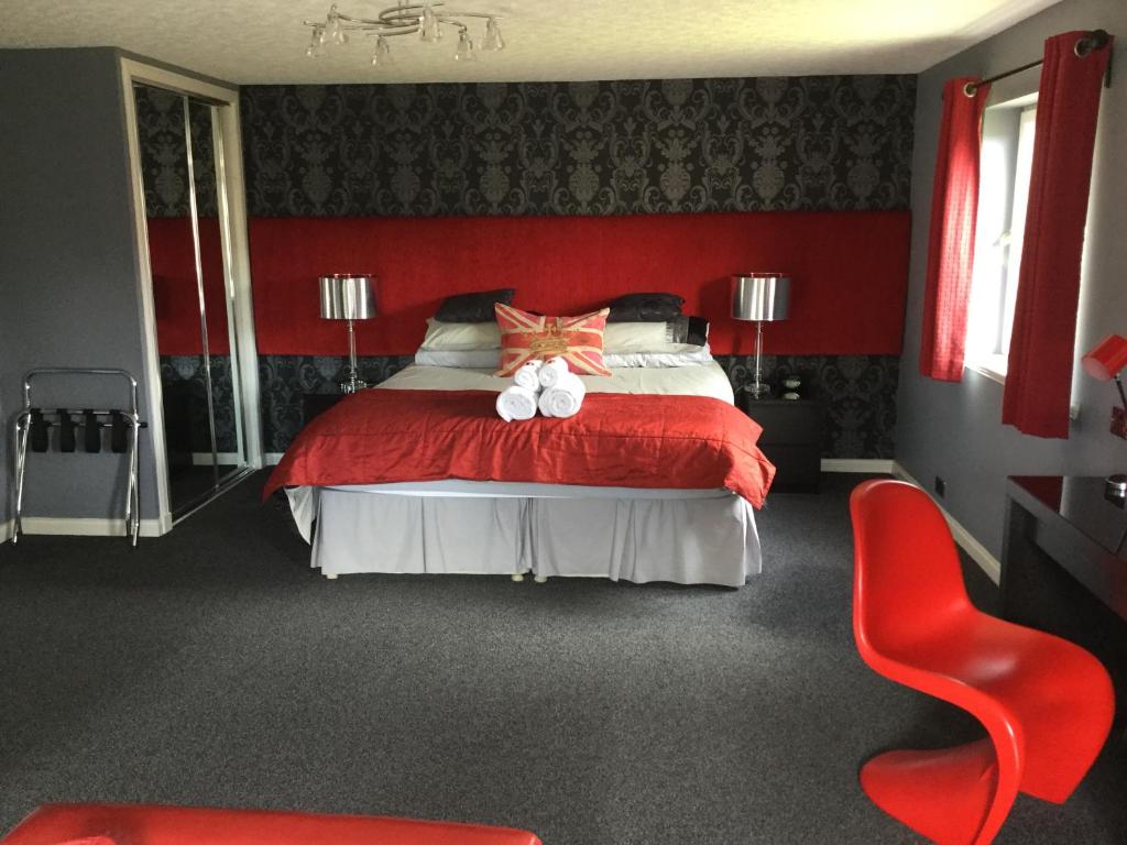 a red bedroom with a bed with two stuffed animals on it at Dionard Guest House in Inverness