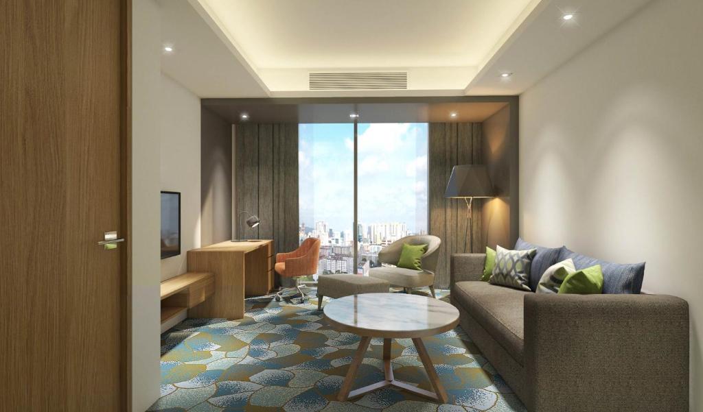 un salon avec un canapé et une table dans l'établissement Holiday Inn & Suites Penang Prai by IHG, à Bukit Mertajam