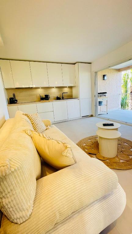 une chambre avec un grand lit avec des oreillers dessus dans l'établissement Bain De Soleil refait à neuf, bord de plage et piscine, proche de Saint Tropez, à Gassin