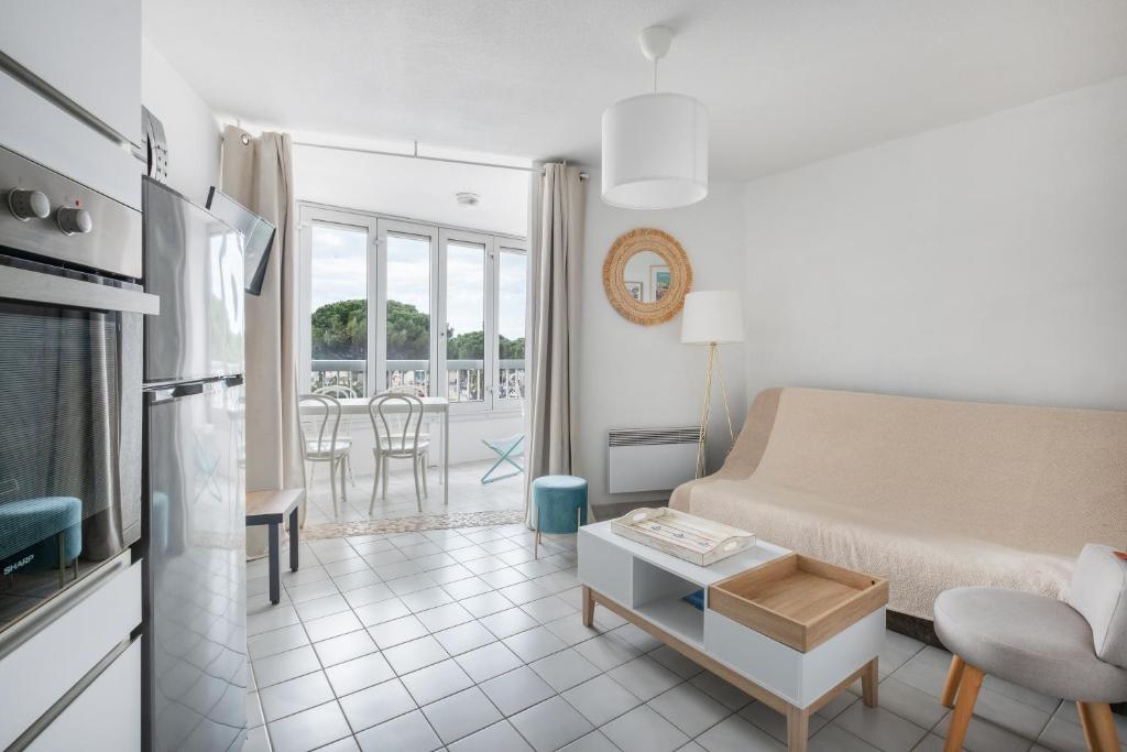 un salon avec un canapé et une table dans l'établissement AS25421-P2 à 2 pas de la plage avec parking privé, au Grau-du-Roi