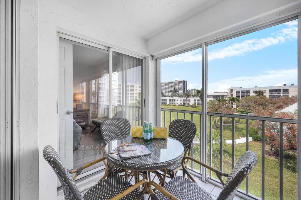 a balcony with a table and chairs with a view at Coastal condo just a short walk away from the beach in Marco Island