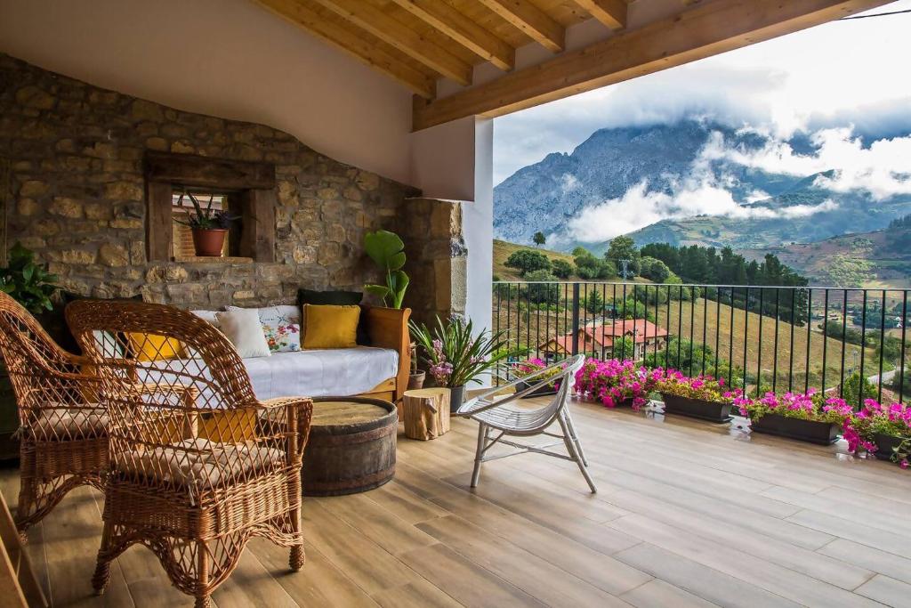 a bedroom with a bed and chairs on a balcony at El Mirador de Armaño G-10235 in Armaño