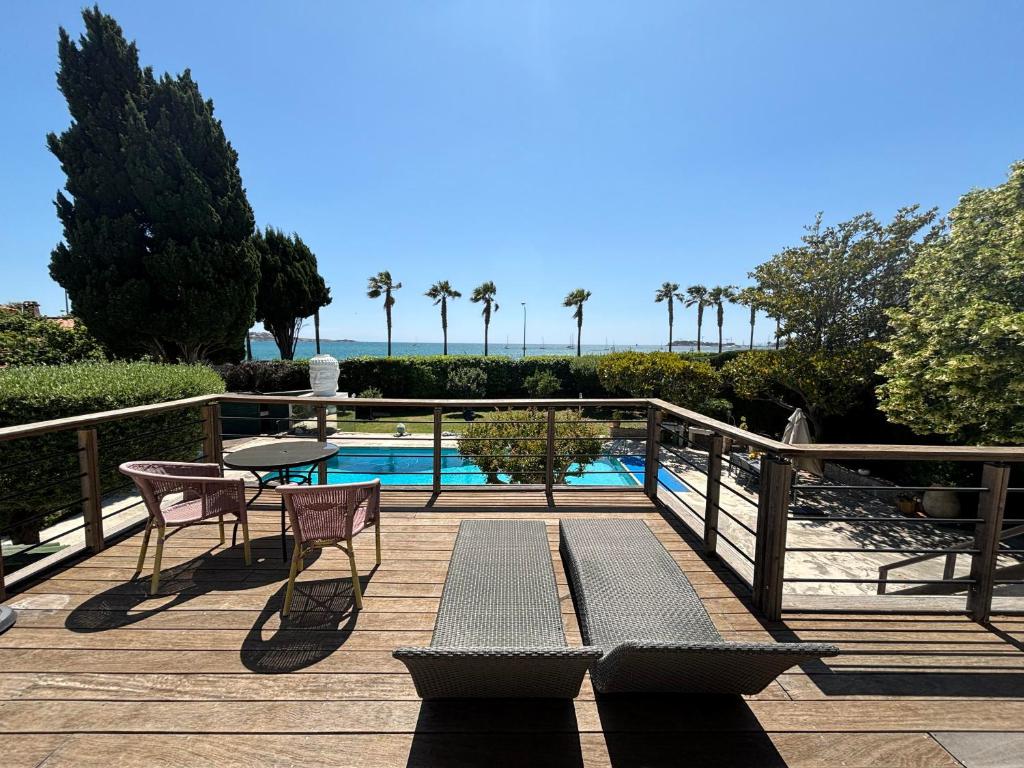 - une terrasse avec une table et des chaises à côté de la piscine dans l'établissement Magnifique Villa en bord de mer, à Sanary-sur-Mer