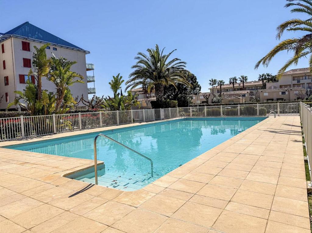 - une piscine dans un complexe avec des arbres et des bâtiments dans l'établissement Studio cabine 4 personnes,copropriété avec Piscine, au Lavandou
