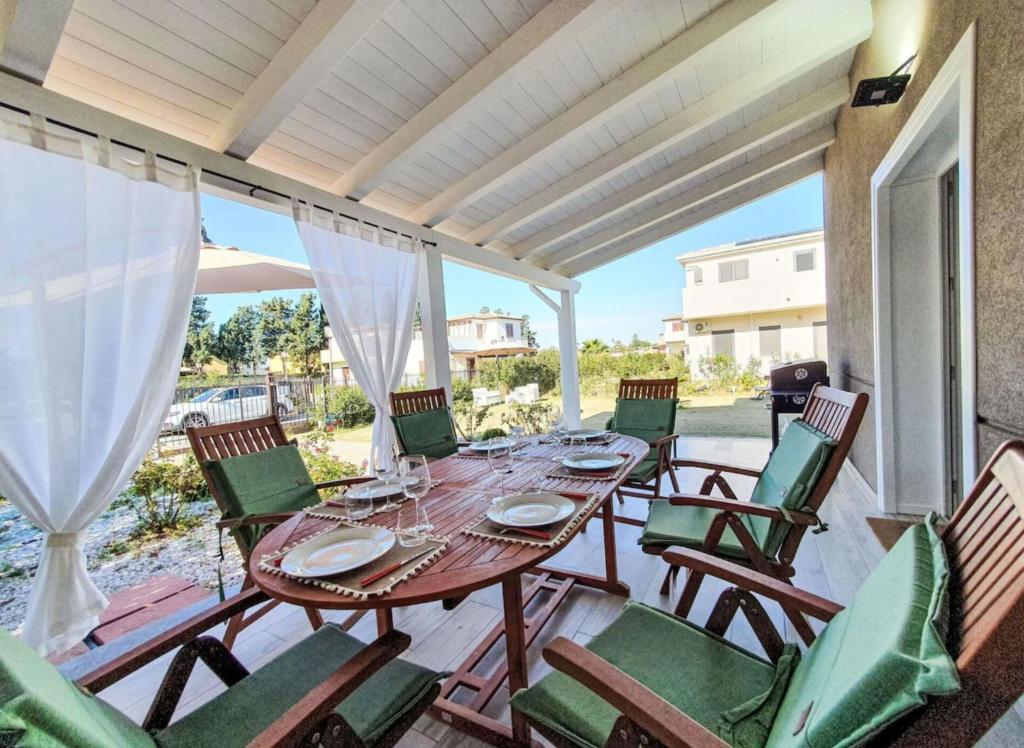 a patio with a wooden table and chairs at Villa Charme & Relax in Campofelice di Roccella